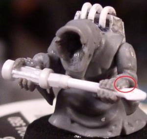 His thumb is circled red. I drilled a hole through his fist <br/>and then cut a gap between his knuckles to squeeze<br/> the screwdriver into.