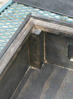 The intersection of the side and back rails, on the support dowels.