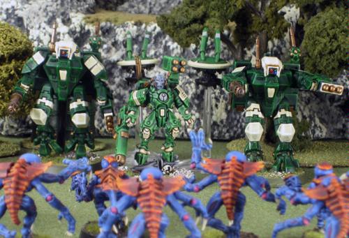 A Tau Commander and Crisis suits unit unleash their firepower into charging Genestealers